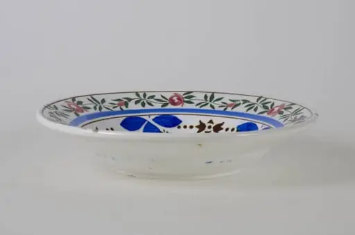 Farfurie de formă tronconică, adâncită; este decorată cu motive florale pe toată suprafața; florile de pe margine sunt încadrate de trei cercuri concentrice dintre care una spre exterior și două spre interior; cromatică: fond alb, motive: roșu; verde; albastru; maro; galben. Pe fund are o ștanță: trei cercuri concentrice. Tot pe fundul vasului sunt două incizii în care este introdus un șnur folosit la agățarea vasului pe perete., by Unknown