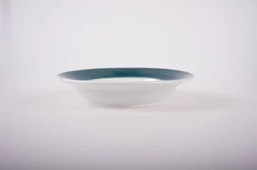 Farfurie de formă tronconică, adâncită; pe fund are găuri pentru agățare. În centru este decorată cu motive florale; marginea este pictată verde; pe fund are trei cercuri concentrice. Cromatică: fond: alb; motive: verde; vișiniu; albastru; galben., by Unknown
