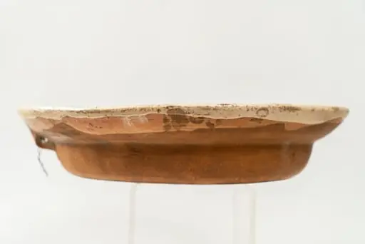 Farfurie mare, adâncă, cu buză răsfrântă; piesa este modelată la roata olarului și angobată cu humă albă pe fața interioară. Decorul este unul figurativ, realizat în manieră naivă, reprezentat de un soldat în uniformă verde, ținând în mâna dreaptă hățurile calului maro pe care este încălecat. Aceste figuri sunt încadrate într-un cerc format din două linii albastre. Bordura interioară a farfuriei este decorată cu un șir continuu format din motive geometrice (linii concave de culoare maro și puncte de culoare verde). Cromatica: alb, maro, verde, galben, albastru. Piesa este smălțuită transparent pe fața decorată., by Unknown