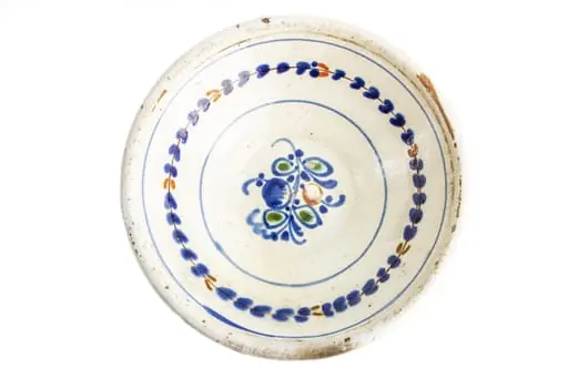 Formă tronconică; fond alb; culori: albastru, verde, cărămiziu; în centrul farfuriei este amplasat un buchet din flori albastre și una de culoare cărămizie, cu frunze verzi, înscris într-un cerc de culoare albastră. Pe perete este amplasat un vrej circular cu frunze albastre și cîteva de culoare cărămizie. Sub buză este dispus un cerc albastru., by Unknown