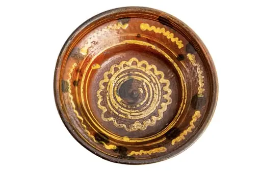 Formă tronconică; fond cărămiziu; culori: galben, verde, brun. În centru este amplasată o spirală de culoare galbenă trasată cu cornul înscrisă într-un val circular de culoare similară care sugerează un soare; pe perete strachinei sînt amplasate șase segmente de linie vălurită de culoare galbenă și pete de culoare brună., by Unknown