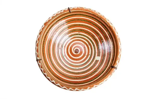 Formă tronconică; fond cărămiziu; decorul amplasat pe toată suprafața constă într-o spirală de culoare albă dublată discret de una de culoare verde. Buza vasului este decorată cu un val circular de culoare albă. Folosită la decorarea interiorului țărănesc în așa numita - cameră bună., by Unknown