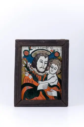 Icoana îi reprezintă pe Sfântul și Dreptul Iosif, Logodnicul PreaCuratei Fecioarei Maria, cu Pruncul Iisus Hristos în brațe. Icoana este mai rară, din punctul de vedere al tematicii compoziționale abordate. Sfântul Iosif este înveșmântat cu un hiton - tunică roșie vermillon, cu mânecile și bordura verde mușchi-de-pădure sau nuanță de China. Pruncul Iisus este dezbrăcat, dar acoperit de veșmântului protector al Sfântului Iosif. În mâna dreaptă Dreptul Iosif Logodnicul ține o ramură de crin, simbolul Fecioriei și a BuneiVestiri. Crinul este ținut împreună cu mânuța Pruncului Sfânt. Aureola Sfântului Iosif este mai aparte, asemenea sfinților catolici. Fondul icoanei este cerul albastru regal, în registrul superior, un câmp luminos de galben-bronziu, în registrele inferior și mediu, pe laterale și un chenar decorativ geometrizant alb-ivoriu. În registrul superior, asemenea unei arcade de boltă, este o ghirlandă de ruje roz - 2 elemente florale. Inscripția din româno-chirilică se traduce Sf Iosif și Iisus. Cromatica este armonioasă și luminos-pastelată: roșu vermillon, verde mușchi-de-pădure, albastru regal, alb-ivoriu, crem, bej, nisipiu, galben-ocru, bronziu, alb, negru. Icoana este din Nordul Transilvaniei, Nicula., by Unknown