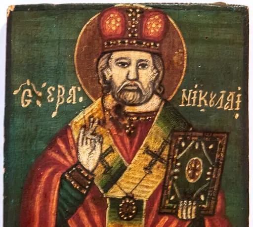 Icoana îl reprezintă pe sfântul Nicolae în ipostaza de mare ierarh, binecuvântînd cu mâna dreaptă iar în stânga ținînd Cartea Sfântă. Sfântul este redat 3/4, cu mitră bipartită pe cap(ipostaza de iarnă), barba tunsă scurt, căruntă. Expresia sobră. Proporțiile respectate. Linia de contur la chip și la mâini accentuată.În jurul capului aureolă delimitată de o linie subțire, albă. Veșmintele simple(sacos roșu cărămiziu, deschis la gât, epitrahil alb verzui, brodat cu cruci drepte, cu brațele egale, stihar albastru cu mânecuțe decorate.) Faldurile sunt definite prin linii albe, groase. Fondul este unitar, albastru de Prusia. Inscripția cu majuscule albe, cu prescurtări, la nivelul umerilor. Chenar îngust, negru. Pictura exfoliată, în colțul inferior stâng., by Unknown