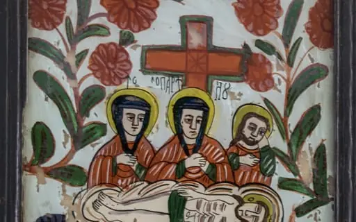 Icoana redă momentul următor coborârii de pe cruce, jelirea lui Hristos, într-o manieră specifică fazei de decădere a picturii pe sticlă. În centrul compoziției, Isus întins pe piatra din Efes(modul cum este pictată arată că iconarul nu cunoștea semnificația), pe un giulgiu alb. În variantele niculene ale Plângerii, scena se reduce la prezența a doar trei personaje, aici două femei(Fecioara Maria în mijloc, una dintre mironosițe) și, ușor retras în spate, gânditor, un apostol tânăr cu barbă(posibil Sf. Ioan Evanghelistul, deși acesta era imberb) .Isus este întins, cu ochii închiși, părul lăsat pe umeri, trăsături anatomice redate schematic, în jurul mijlocului o eșarfă verde.În jurul capului are nimbul cruciger cu însemnele consacrate, prescurtarea de la Iahve(Eu sunt Cel ce sunt) Cele două Marii au fețele triste, trăsături pătrățoase, ținînd mâinile la piept, semn de jale. Pe cap au câte o broboadă neagră. Veșmintele în culorile consacrate, predominant roșii, cu accente de verde. Aureole în jurul capului, deși în iconografie nimbul se atribuie mai târziu unor persoane. Crucea, pictată în roșu(chenar verde) străjuiește simbolic scena. Câmpul bleu este inundat de tulpini sinuase cu câte trei flori mari, roșii, conturul amintind de centrele din Boemia. Pământul este sugerat de o porțiune galben ocru, lângă catafalc două flori întunecate(lalele) Inscripția, destul de neclară și trunchiată, este scrisă cu litere negre inegale sub brațele crucii. Compoziția este echilibrată iar cromatica este dominată de roșu, în dezacord cu tema. Rama profilată este vopsită cu negru, îmbinare oblică ;dos- lemn subțire de brad; Pictura este exfoliată în multe locuri., by Unknown