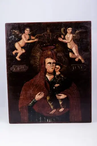 Maica Domnului ține în brațe Pruncul Iisus Hristos, care arată cu mâna dreaptă înspre Maica Domnului, prezentându-ne-o. Maica Domnului este înveșmântată în mantie cu maforion roșu-stacojiu, cu interiorul negru. Maica Domnului are aureola în raze luminoase de soare. Pruncul Iisus Hristos este înveșmântat cu sacos și omofor brun spre negru, cu coroană și aureolă pe cap. Fondul icoanei este negru întunecat, în contrast fiind cu lumina chipurilor și cromatica veșmintelor. În registrul superior sunt doi îngeri îndreptați spre coroana stilizată a Maicii Domnului, făcând gestul Încoronării. Îngerii sunt pictați asemenea unor putti, din pictura barocă. Cromatică este armonioasă: roșu stacojiu, brun, acajou, brun-ocru, brun, bej, alb, verde-olive, negru. Inscripția din româno-chirilică se traduce MP IC XC Maica Domnului Iisus Hristos. Icoana este pictată în manieră barocă și are atmosfera catolică., by Unknown