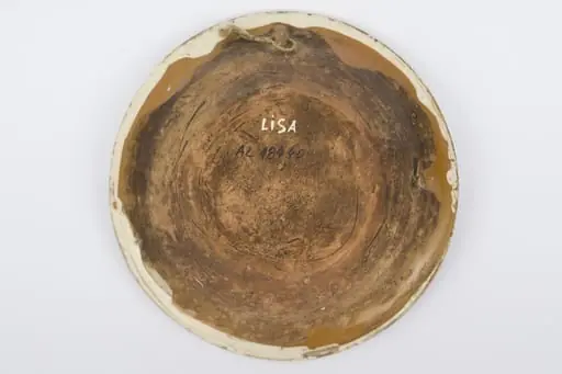 Recipient ceramic smălțuit la interior, de formă tronconică, cu baza plată, pereții înalți și marginea profilată. Peste stratul crem de angobă a fost pictat decorul geometrizant și fitomorf stilizat: Pe fundul vasului au fost realizate patru flori maro, cu mijlocul verde și albastru, fiind mărginite de patru grupuri de câte nouă puncte verzi și albastre (două câte două, în diagonală). Cel de-al doilea registru pictural a fost realizat marginal, pe buza piesei fiind încadrat între două linii circulare drepte un șir de „V-uri” succesive. Farfuria era folosită în gospodărie pentru decorarea interioarelor sau servirea hranei. Prezintă uzură funcțională: Cromatică: fond: cărămiziu; crem; motive: maro; verde; albastru., by Unknown