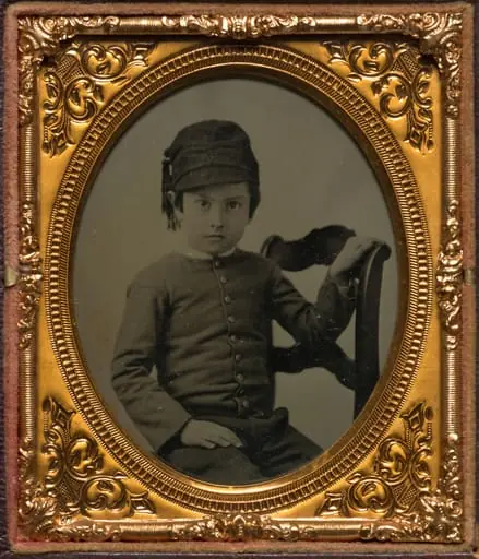 Seated boy in tasseled cap, by Unknown