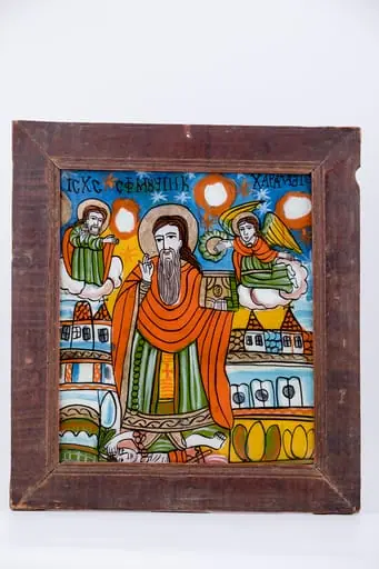 Sfântul Mare Mucenic Haralambie, făcător-de-minuni, este cel mai bătrân mucenic din cei prăznuiți de creștini. Este cunoscut ca și făcător-de-minuni, vindecător de boli și ocrotitor al caselor familiilor creștine. Central este pictat Sfântul, îmbrăcat cu veșminte liturgice, arhierești, cu sacos verde-văratic, felon roșu vermillon și epitrahil galben, cu o cruce mică orange, cu aureolă. Fiind foarte bătrân, are barbă albă, lungă sură și părul șaten-castaniu lăsat pe umeri. În mâna stângă are Sfânta Evanghelie închisă și cu mâna dreaptă Binecuvântează, și ține în lanț ciuma, reprezentată antropomorfic. Ciuma, simbolizând boala incurabilă și moartea, are secera în mână și coarne de diavol, fiind, totodată și păcatul, patima, aducătoare de moartea duhovnicească. În registrul superior, în dreapta este Dumnezeu-Tatăl Binecuvântând, de pe o mandorlă de nouri albi-crem și în stânga sfântului ierarh, este un înger îngenuncheat pe un nor, cu aripile galbene, care așează cununa de mucenicie pe capul Sfântului Haralambie. În registrul inferior, este o alternanță de câmpuri galbene-verzi cu elemente florale de câmp, iar în registrul mediu sunt elemente de arhitectură. Fondul icoanei este cerul albastru regal cu steluțe albe-roșii, astfel creându-se o simetrie compozițională. Cromatica este armonioasă: albastru regal, cobalt, roșu vermillon, galben chihlimbar, verde văratic, brun, bej, crem, alb, negru se întrepătrunde estetic cu detaliile minuțioase ale desenului. Inscripția din româno-chirilică se traduce IC XC Iisus Hristos Sf Mucenic Haralambie. Icoana este din Țara Oltului, Șcheii Brașovului., by Unknown