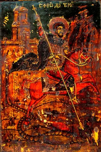 Sfântul Sfântul Teodor Tiron călare pe un cal roșu, omorând balaurul.Redat ca sfânt militar, cizme înalte, tunică 3/4 roșie, lorica scurtă, mantie bleumarin fluturând în vânt, pantaloni mulați. Capul descoperit, părul bogat,ondulat, scurt, castanii, expresia chipului sobră. Nimb mărginit de o linie galbenă,dublată la exterior de formațiuni punctiforme albe, în formă de floare.Pe scut o figură antropomorfă, în relief. În mână ține o suliță lungă, subțire, cruciformă, cu care omoară balaurul, cu o coadă lungă, încolăcită pe după picoarele calului, aripi mari, deschise, roșii, capul mic. Calul este bine proporționat, coada este înnodată, șaua și harnașamentul decorate fin cu alb. Pe fundal relief muntos,culmi abrupte în partea dreaptă. În cea stângă, sunt pictate zidurile unei biserici înalte. Linia albă, cu care este executat conturul și decorurile stilizate, fitomorfe foarte fină. Fond de culoare albastru verzui, marginea excizată fiind pictată jumătate cu roșu, cealaltă exterioară grena. Inscripția sus.- litere albe, caligrafice și prescurtări. Pictura este întunecată, cu urme de murdărie, fum și mici lacune ale stratului pictural. Pe cantul superior - cui de metal ,vechi. Compoziția este armonioasă, proporțiile respectate, desenul fin, paleta cromatică, dominată de tonuri calde în contrast cu fondul metalizat. De numele Sfântului Teodor este legată sărbătoarea populară a Sântoaderului, ce se ține în prima săptămână a postului Mare(Sâmbăta lui Toader; Tudorusale), by Unknown
