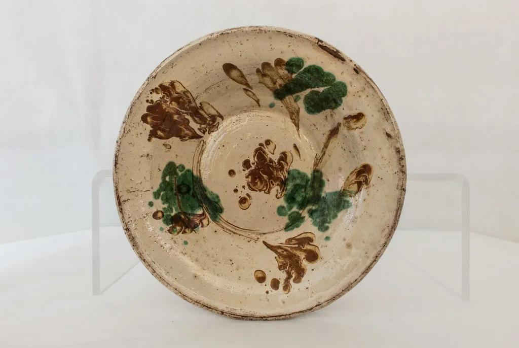 Vas de formă rotundă, adâncită, cu pereții evazați, smălțuit în interior, cu marginea ușor rotunjită, cu decor abstract realizat în tehnicile stropirii și scurgerii dirijate a colorantului maro. Cromatică: verde, maro, bej., by Unknown, 1850