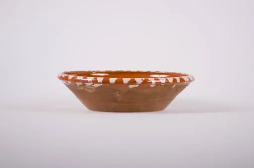 Vas de formă tronconică, adâncit; pe fund are găuri pentru agățare, Este smălțuit interior și exterior (buza). Decorat cu motive geometrice: linie, punct; motive avimorfe: păun. Cromatică: fond: maro; motive: alb; negru; verde., by Unknown