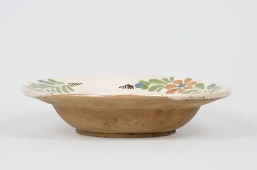 Vas de formă tronconică, adâncit smălțuit în interior. Acesta este decorat pe margine cu motive vegetale și florale pe un registru dispus în zona diametrului maxim. Cromatică: fond cărămiziu (exterior); fond alb (interior); verde; maro; albastru., by Unknown