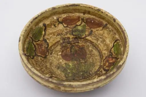 Vas din lut de formă circulară cu profil tronconic, smălțuit la interior și buza dreaptă. Decorat cu motive vegetal-florale pictate cu pensula pe suprafața interioară: pe fundul vasului, central, este pictată o floare cu frunze iar pe pereții vasului flori grupate câte trei. Pe dos, blidul este prevăzut cu un orificiu circular, pentru agățarea de perete. Rol decorativ. Prezintă urme de uzură funcțională. Cromatică: fundal exterior cărămiziu, fundal interior galben; motive: verde, cărămiziu, maro., by Unknown