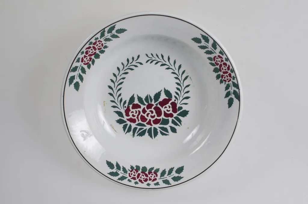 Vasul are formă tronconică, adâncită. Este decorat cu motive florale, vegetale și geometrice; are trei flori pe margine ce sunt delimitate de o linie; în centru este decorat cu un buchet format din trei trandafiri; pe fund are trei cercuri concentrice. Vasul este smălțuit interior-exterior. Cromatică: fond alb; motive: verde; roșu., by Unknown, 1850