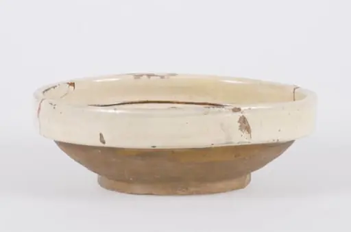 Vasul ceramic are formă tronconică, cu pereții evazați și buza dreaptă și ieșită în afară. Exteriorul pereților și fundul, au fond cărămiziu, restul suprafeței interioare și buza exterioară, având fond alb-gălbui. Decorul este format din două registre despărțite de două cercuri concentrice: unul plasat în marginea buzei și altul în centrul fundului vasului. Primul registru central este decorat cu o floare cu frunze verzi, petale maro și un punct albastru în centru. Al doilea registru amplasat pe pereții interiori ai vasului este format din două flori similare cu cea centrală mărginite spre tulpină și vârf de mai multe frunze, despărțite de două aglomerări de linii de diferite dimensiuni. Cromatică: fond: alb-gălbui; motive: verde; maro; albastru., by Unknown
