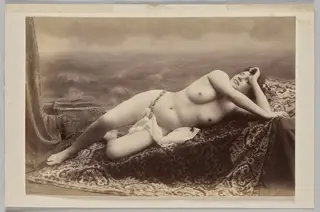 Untitled (reclining nude on carpet against painted backdrop of waves)