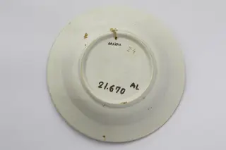 Vas ceramic de formă tronconică. Există două registre ornamentale, unul plasat de jur împrejurul buzei cu motive florale. Al doilea registru plasat în centru de asemenea motive florale. La posterior baza inelară perforată pentru atârnare. Cromatică: fond: alb; motive: verde; albastru.