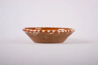 Vas de formă tronconică, adâncit; pe fund are găuri pentru agățare, Este smălțuit interior și exterior (buza). Decorat cu motive geometrice: linie, punct; motive avimorfe: păun. Cromatică: fond: maro; motive: alb; negru; verde., 1850