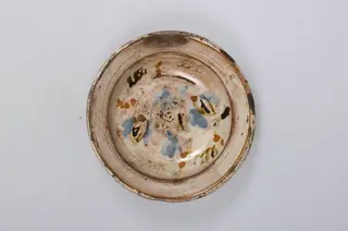 Vas de formă tronconică adâncit, smălțuit în interior. Este decorat pe margine cu motive geometrice: cercuri concentrice, iar în centru cu motive vegetale și florale. Decorul este realziat prin pictare. Cromatică: fond cărămiziu (exterior); fond alb (interior); albastru; maro; portocaliu.