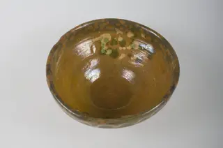Vas de formă tronconică, cu pereții oblici și buza înaltă, lucrat neîngrijit. Este smălțuit în interior și exterior (parțial). Este decorat pe interior cu un mănunchi de puncte albe și verzi. Buza este decorată în exterior cu motive geometrice: linie în val. Cromatică: motive: fond: maro; motive: alb; verde., 1850