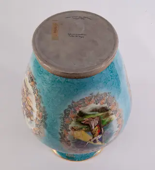 Vas mare din porțelan bleu cu auriu, decorată cu patru medalioane încadrate cu motive florale. Primul medalion reprezentarea unei bătălii din perioada medievală; al doilea medalion reproducerea lucrării lui C. Rosenthal ”România rupându-și cătușele pe Câmpia Libertății”; cel de-al treilea medalion prezintă o scenă de luptă din perioada Marelui Război. Cel de-al partulea medalion prezintă stema RSR, steagul tricolor și un citat dintr-un discurs a lui Nicolae Ceaușescu ”....actul de la 23 August nu a venit din cer ci a fost rezultatul luptelor îndelungate ale poporului român”. Buza vazei este decorată cu o bandă metalică aurie. Pe verso numele artistului Ely Gârboan. Vază oferită lui Nicolae Ceaușescu de reprezentanții Fabricii de Porțelan Curtea de Argeș cu ocazia vizitei de lucru din jud.Argeș, 17 septembrie 1976.