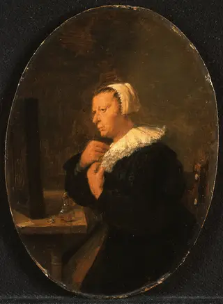 Woman seated at a tabel before a mirror (Dressing up)